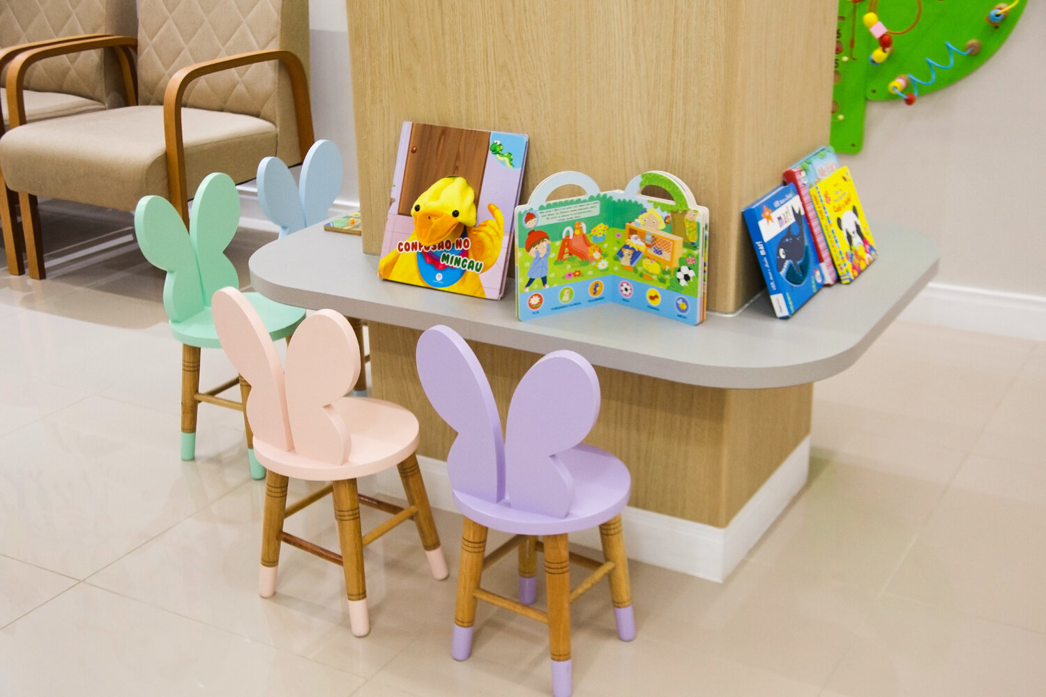 Cantinho infantil da recepção da Neuro Sensus, com cadeiras coloridas e livros
